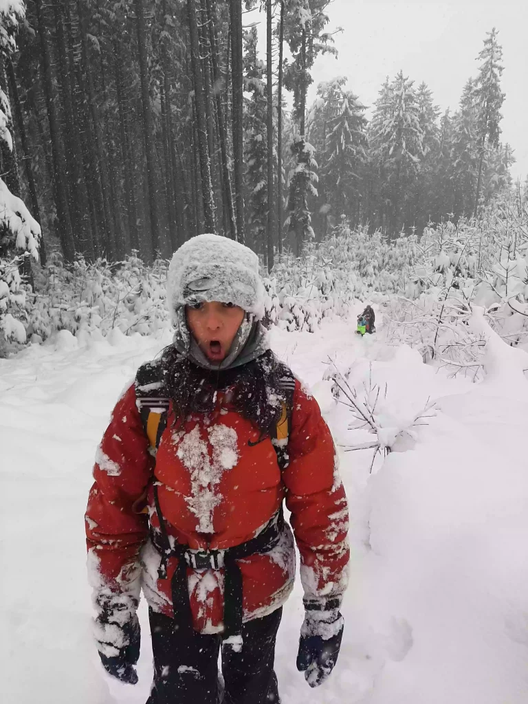Ein Schneebedecktes Kind das im Winterwald läuft